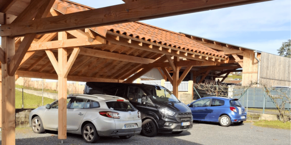 Un carport en bois Douglas asymétrique sur notre parking : un modèle devenu indispensable